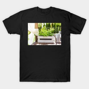 White wooden pot with green herbs on a wooden terrace T-Shirt